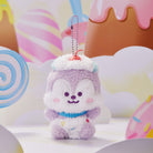 Plush purple squirrel toy with white frosting and a cherry on top, and a metal chain. The toy has a blue collar and is sitting in a colorful, cartoonish candy land.