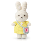 Crocheted bunny doll in yellow dress with blue purse.