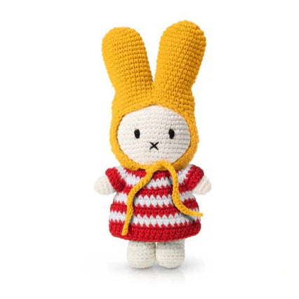 Crocheted Miffy doll wearing a red and white striped dress and yellow bonnet.