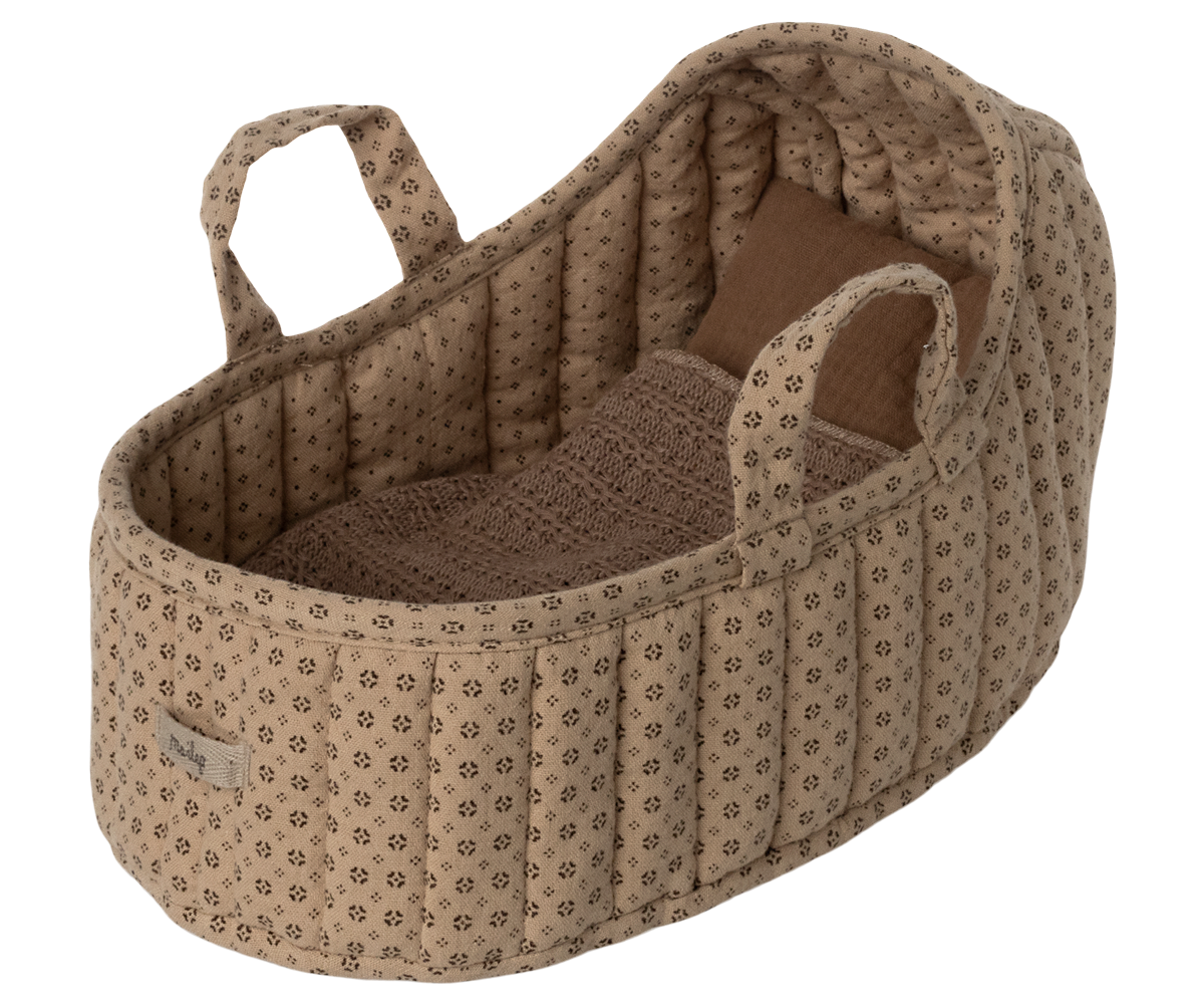 Beige and brown floral print doll bassinet with bedding.