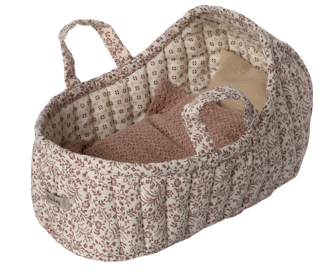 Quilted floral baby Moses basket with bedding.