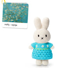 Crocheted toy bunny wearing a blue dress with white flowers.