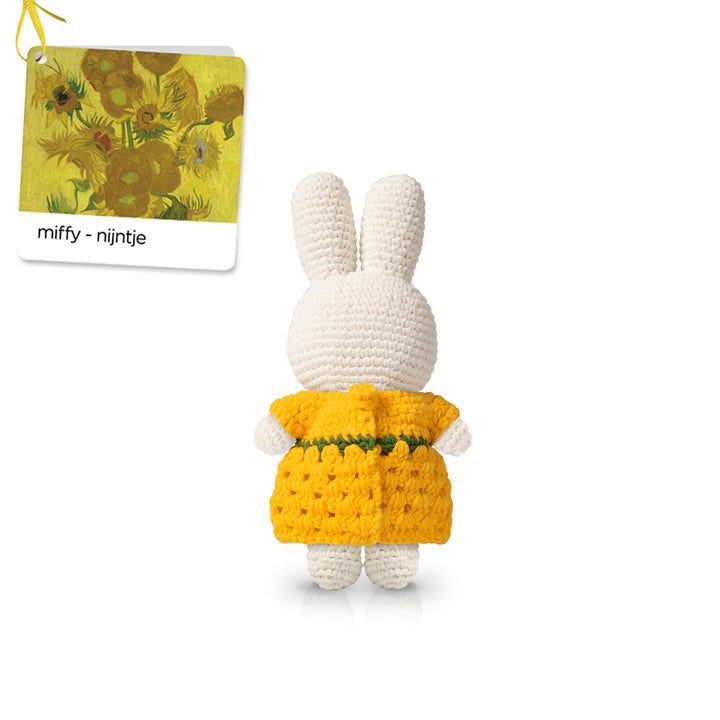 Crocheted white Miffy bunny in yellow dress with green trim, beside tag depicting Van Gogh's Sunflowers.