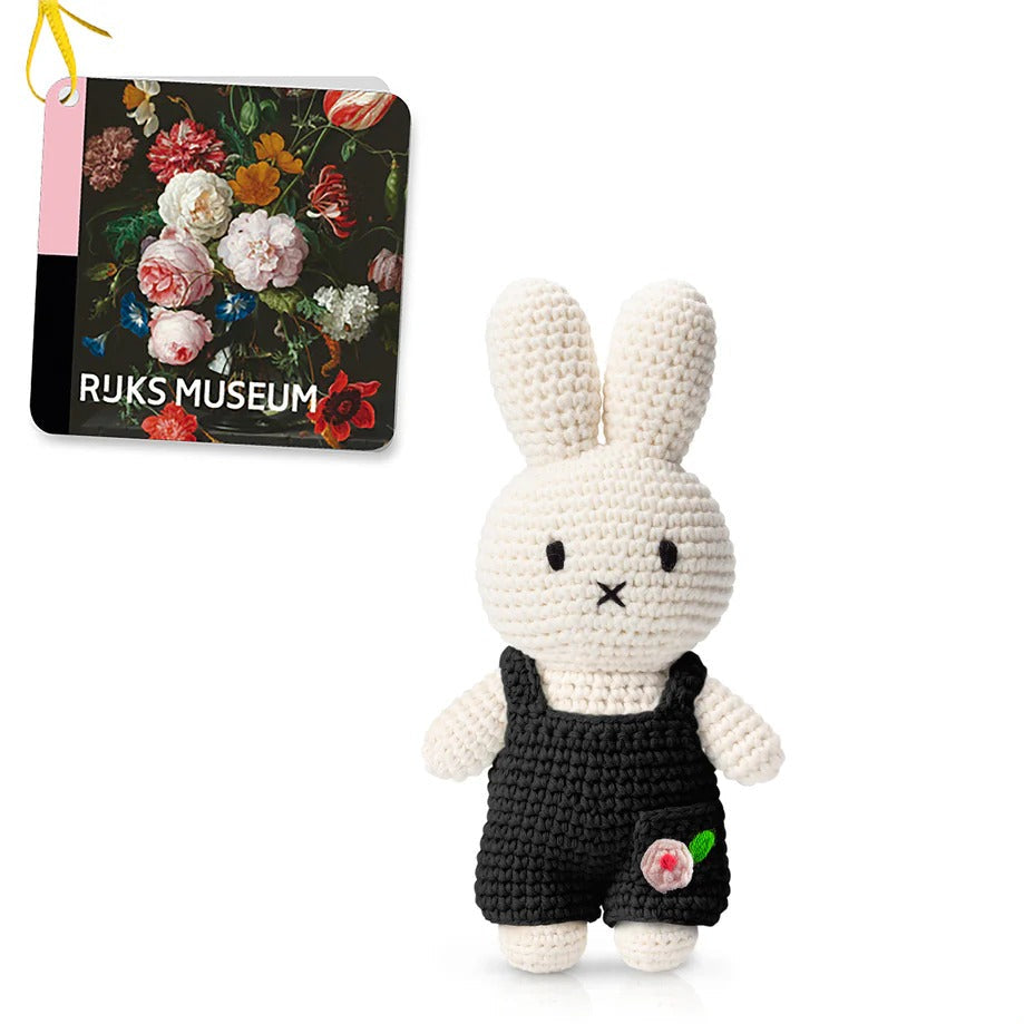 Crocheted Miffy doll in black overalls, with a museum tag.