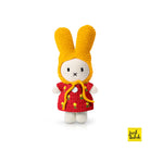 Crocheted bunny doll wearing a yellow bonnet and red dress with yellow flower accents.