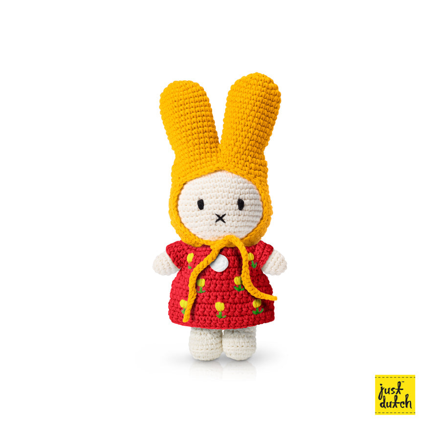 Crocheted bunny doll wearing a yellow bonnet and red dress with yellow flower accents.