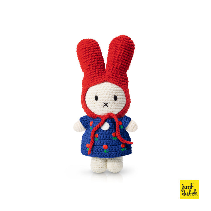 Crocheted Miffy doll wearing red bonnet and blue floral dress.