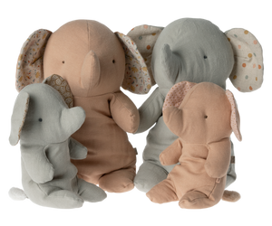 Here are some descriptive alt tags for the image:
*   Four plush elephant toys in beige and gray.
*   Two sets of mama and baby elephant stuffed animals.
*   Cute elephant plushies with patterned ear lining.
*   Beige and gray plush toy elephants.
*   Stack of plush elephants, various sizes.