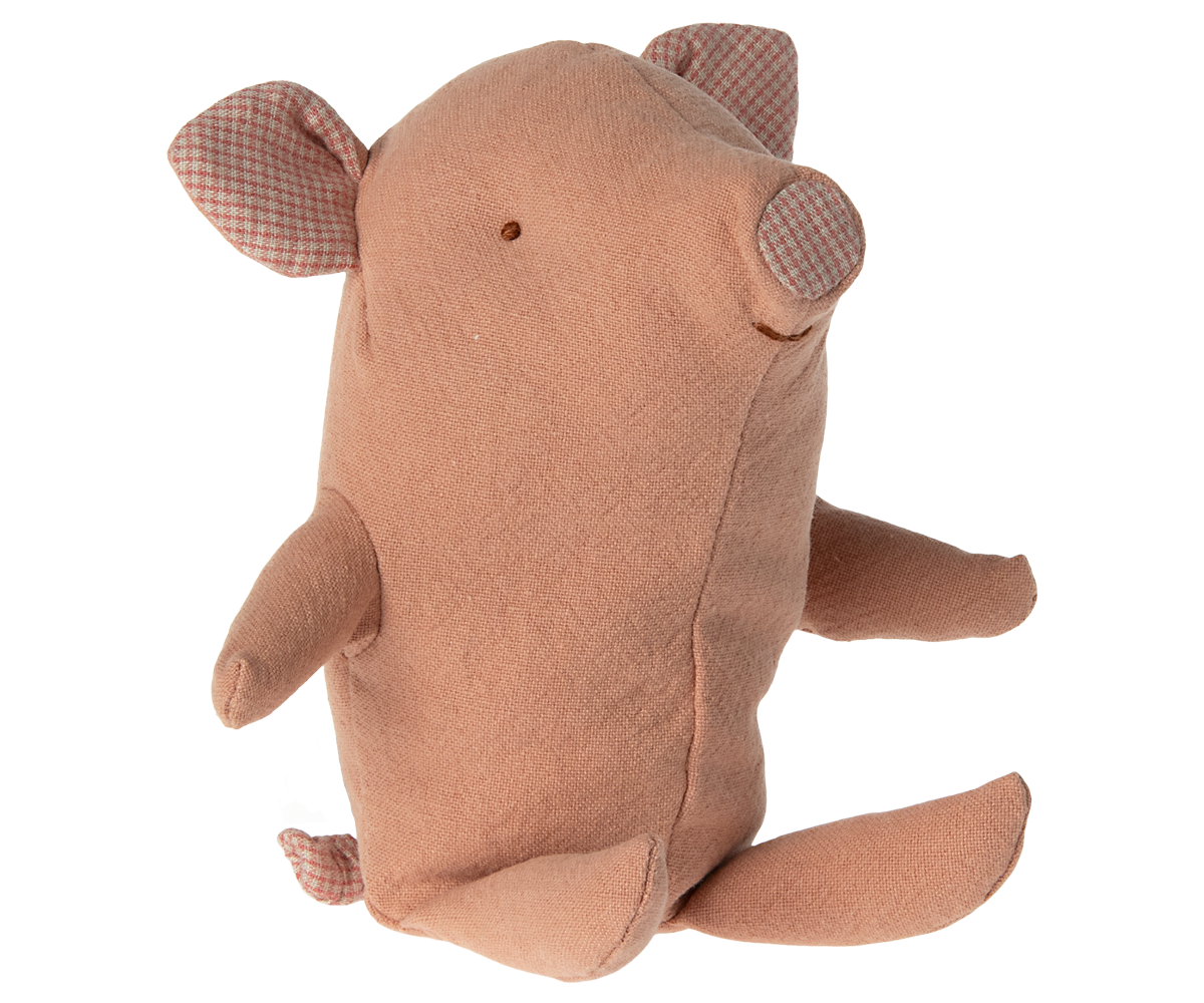 Stuffed pink pig toy sitting up.