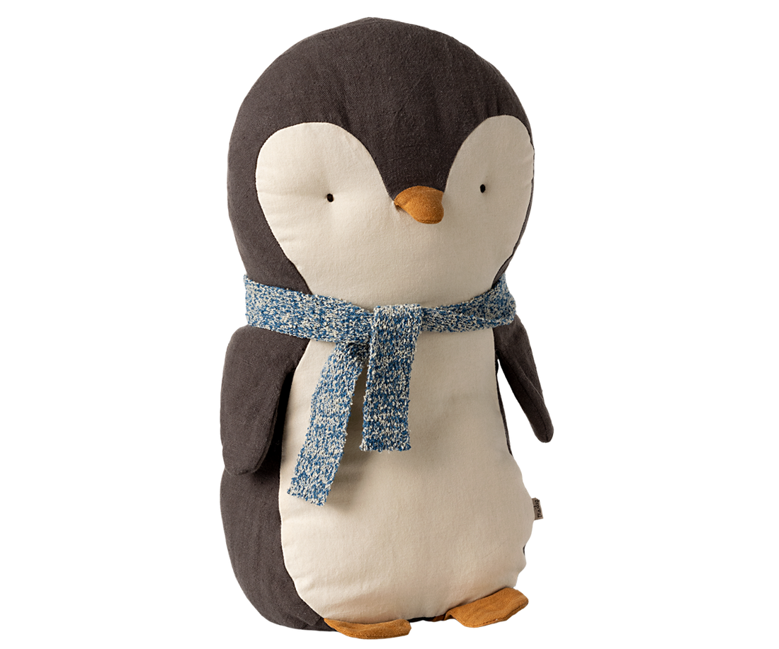 Stuffed penguin toy wearing a blue scarf.