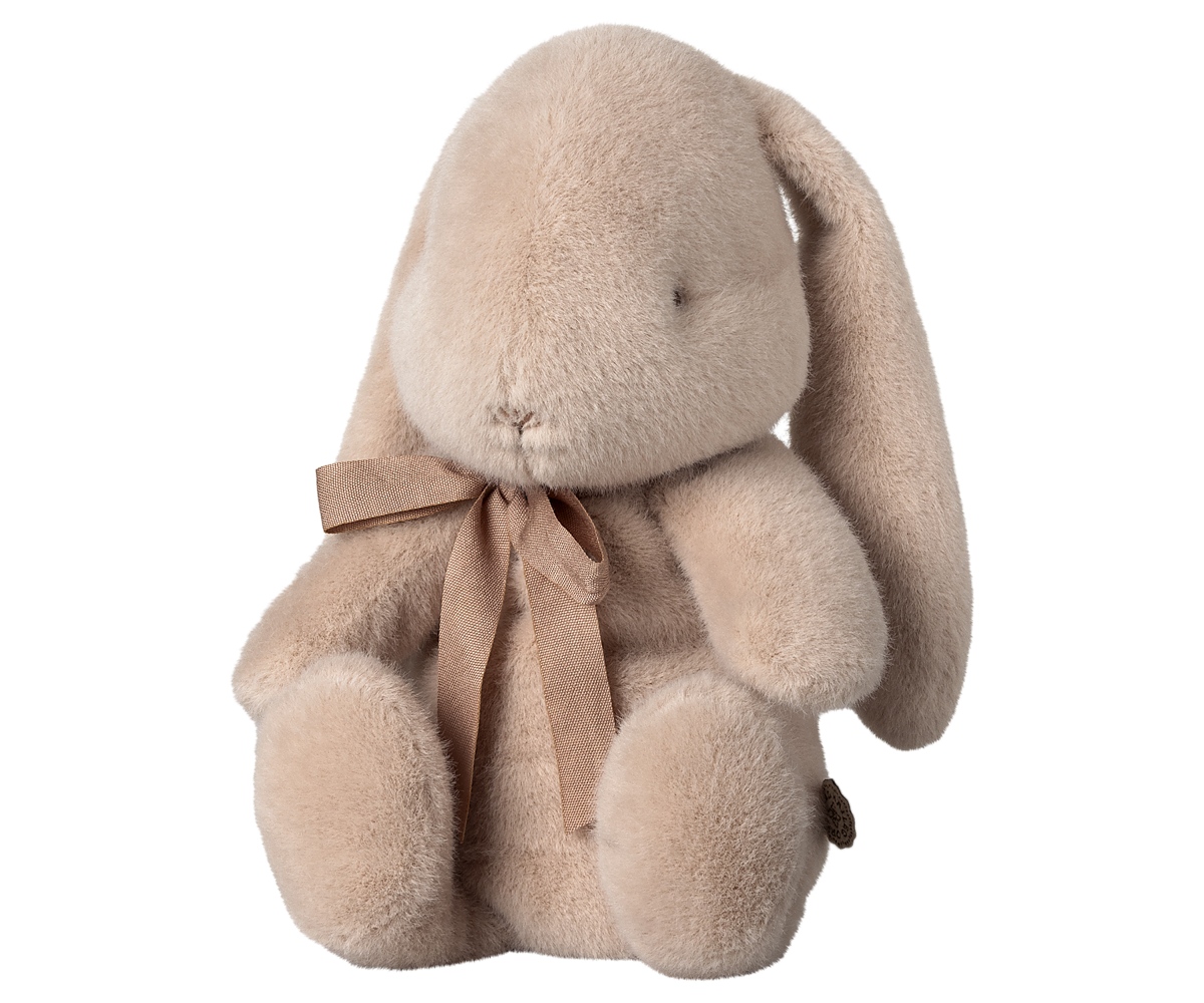 Tan plush bunny toy with a brown ribbon around its neck.