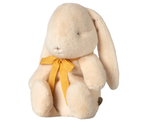 Cream-colored plush bunny with yellow ribbon.