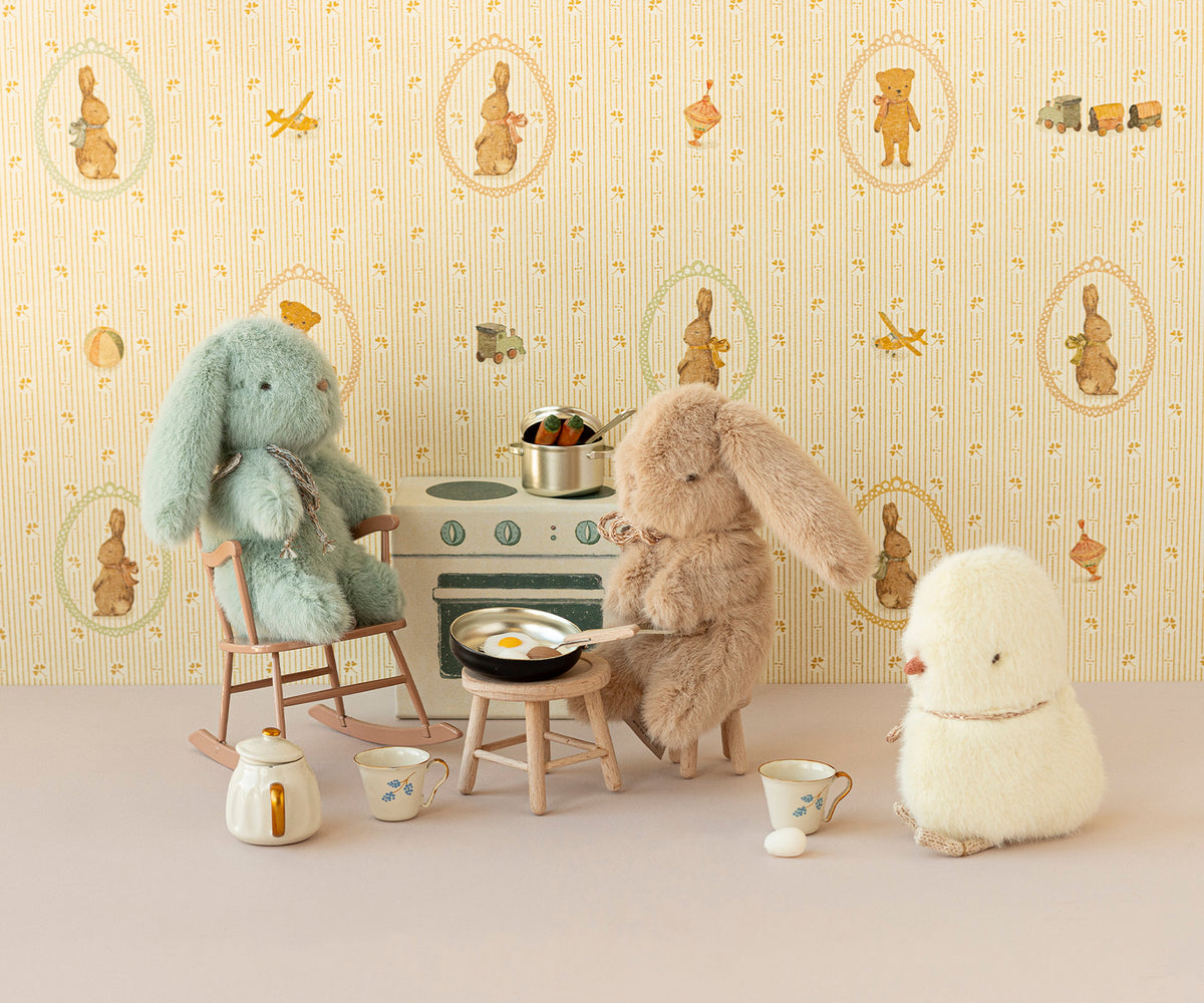 Stuffed bunny and chick toys cooking miniature meal on stove.