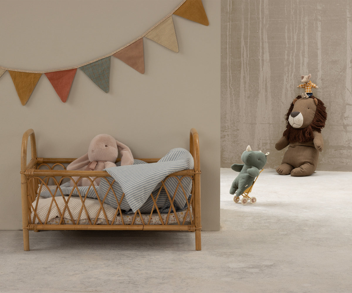 Toy room with a rattan bed, bunting banner, and stuffed animals.