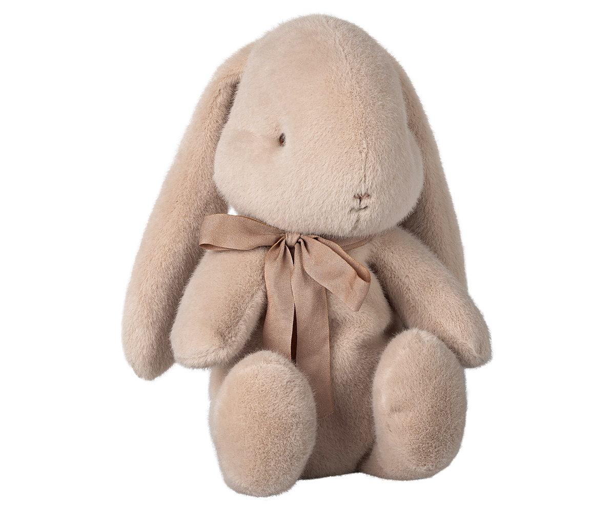 Tan plush bunny with a ribbon around its neck.