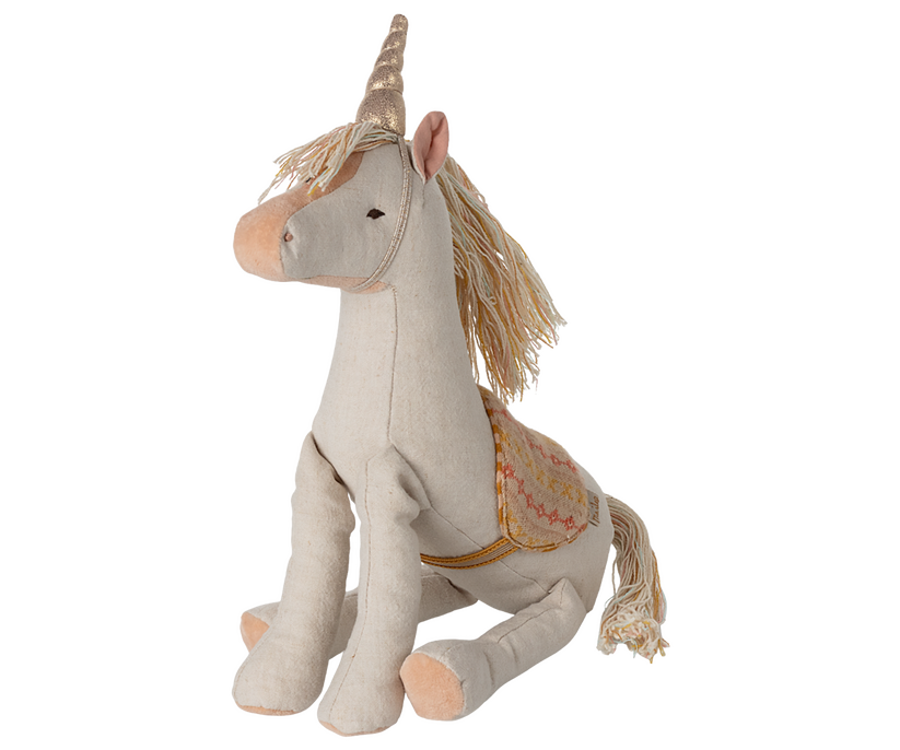 Stuffed unicorn with gold horn and embroidered saddle.