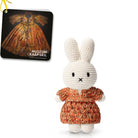Crocheted Miffy doll wearing orange dress, tag featuring historical dress.