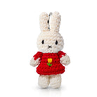 Crocheted white Miffy rabbit with red dress and yellow flower.