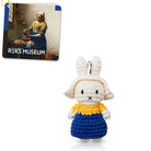 Crocheted Miffy doll in blue dress and yellow top, Rijksmuseum postcard in background.