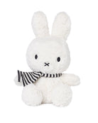 Stuffed white rabbit toy with black and white striped scarf.