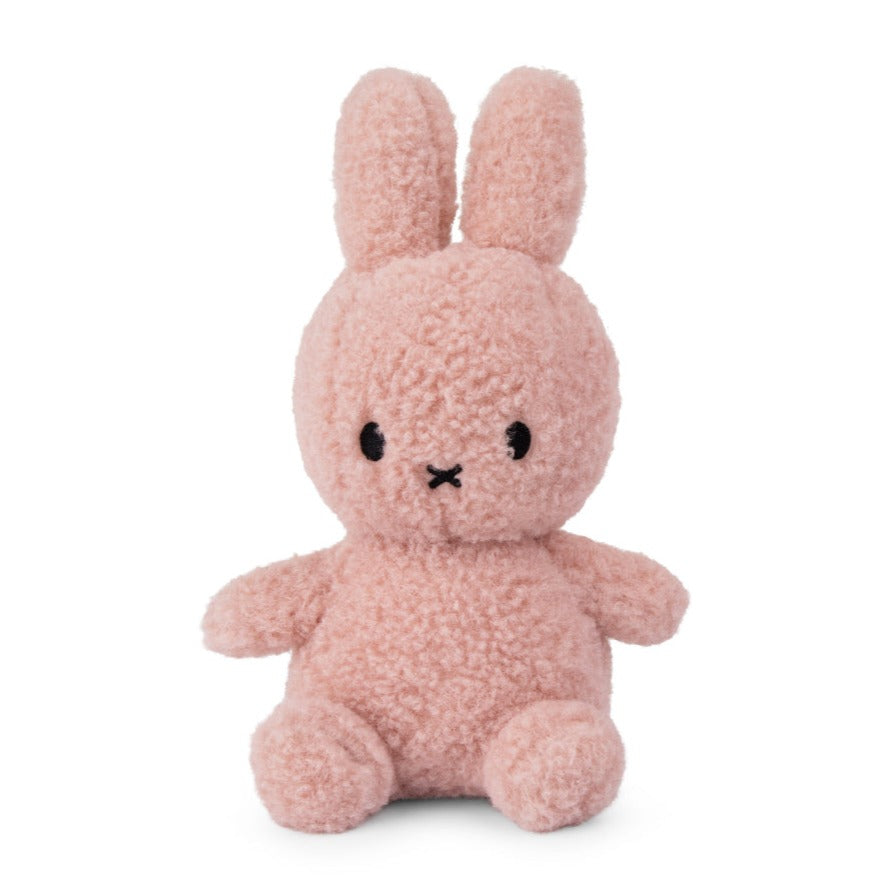 Front view of a fluffy pink Miffy plush toy with a cross-shaped mouth and black bead eyes.