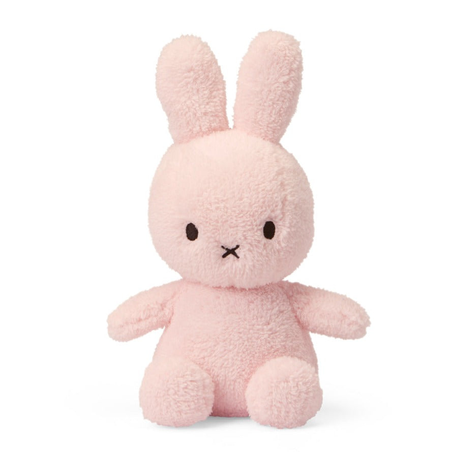 Pink stuffed bunny with upright ears, a stitched X for a mouth, and small round eyes.