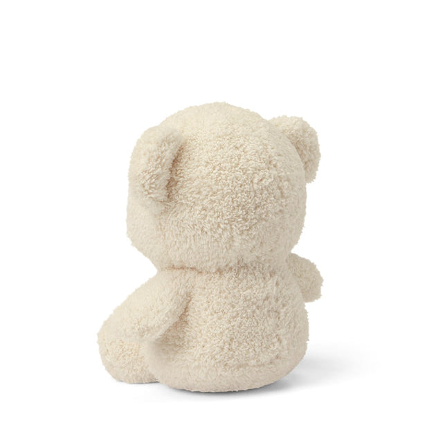 Rear view of a plush, cream-colored teddy bear.