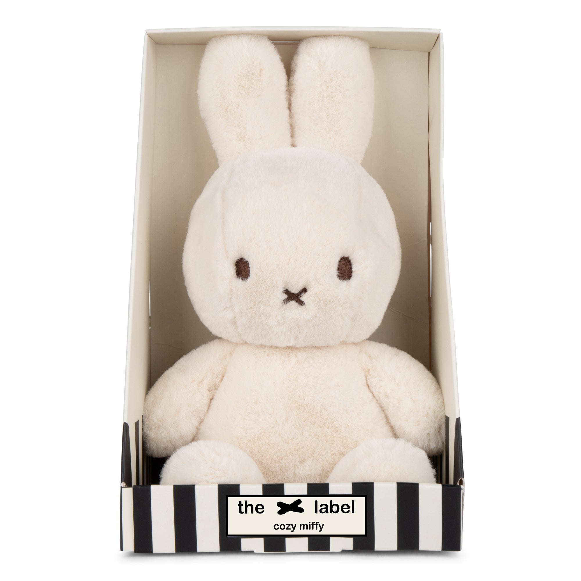 Stuffed Miffy rabbit in box with black and white stripes.