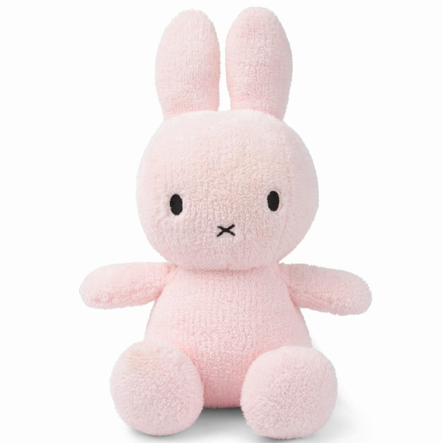 A pink plush bunny with stitched eyes and mouth.