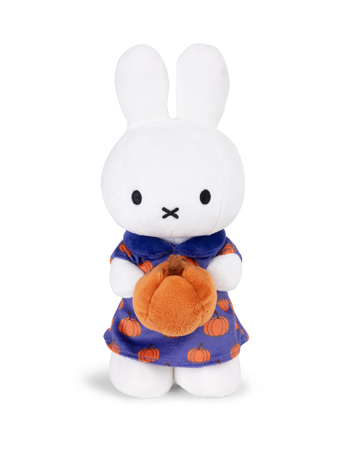 Stuffed white Miffy bunny holding a plush orange pumpkin, wearing a blue dress with pumpkin print.