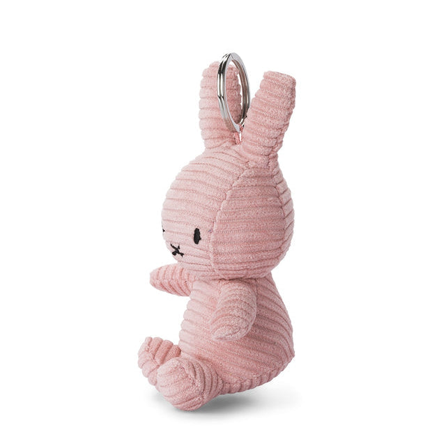 A pink corduroy bunny keychain charm with a silver metal key ring, shown from a side profile on a white background.