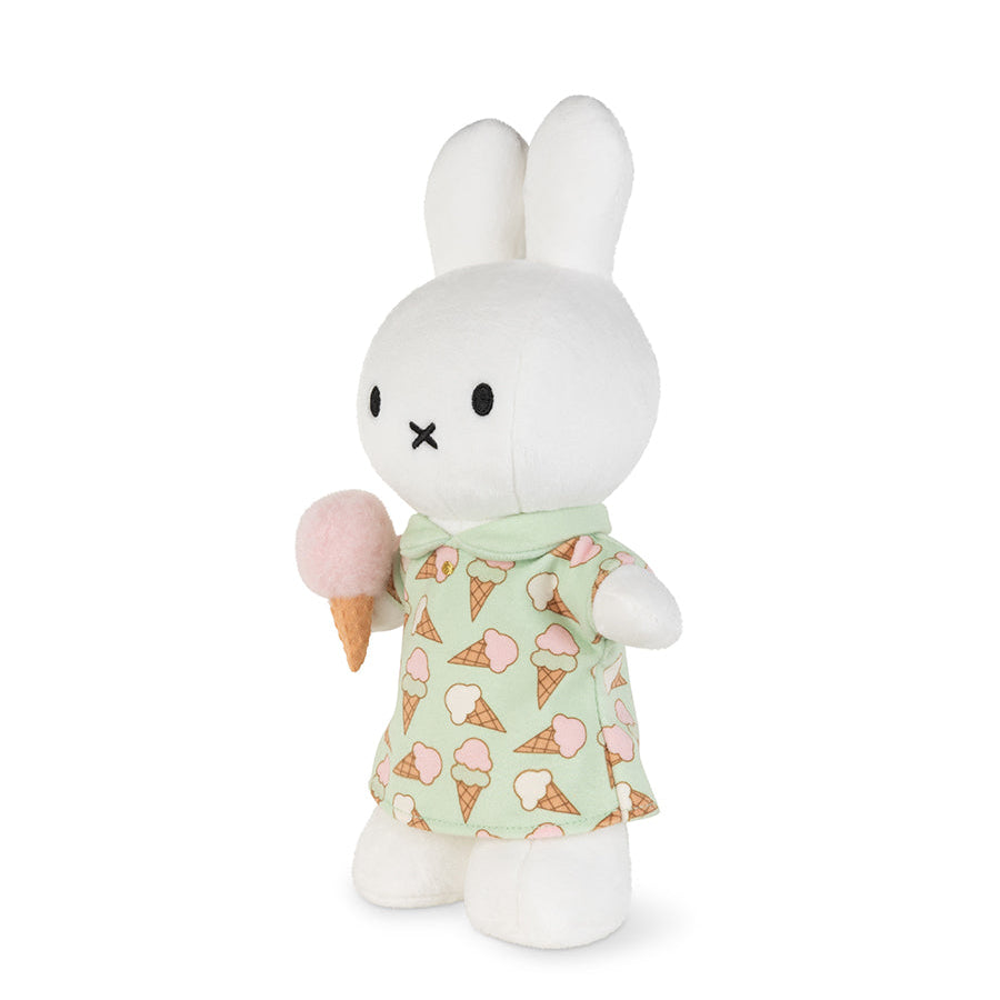 A white plush bunny toy holding a pink ice cream cone, wearing a pale green dress with an ice cream cone print, photographed on a clean white background.