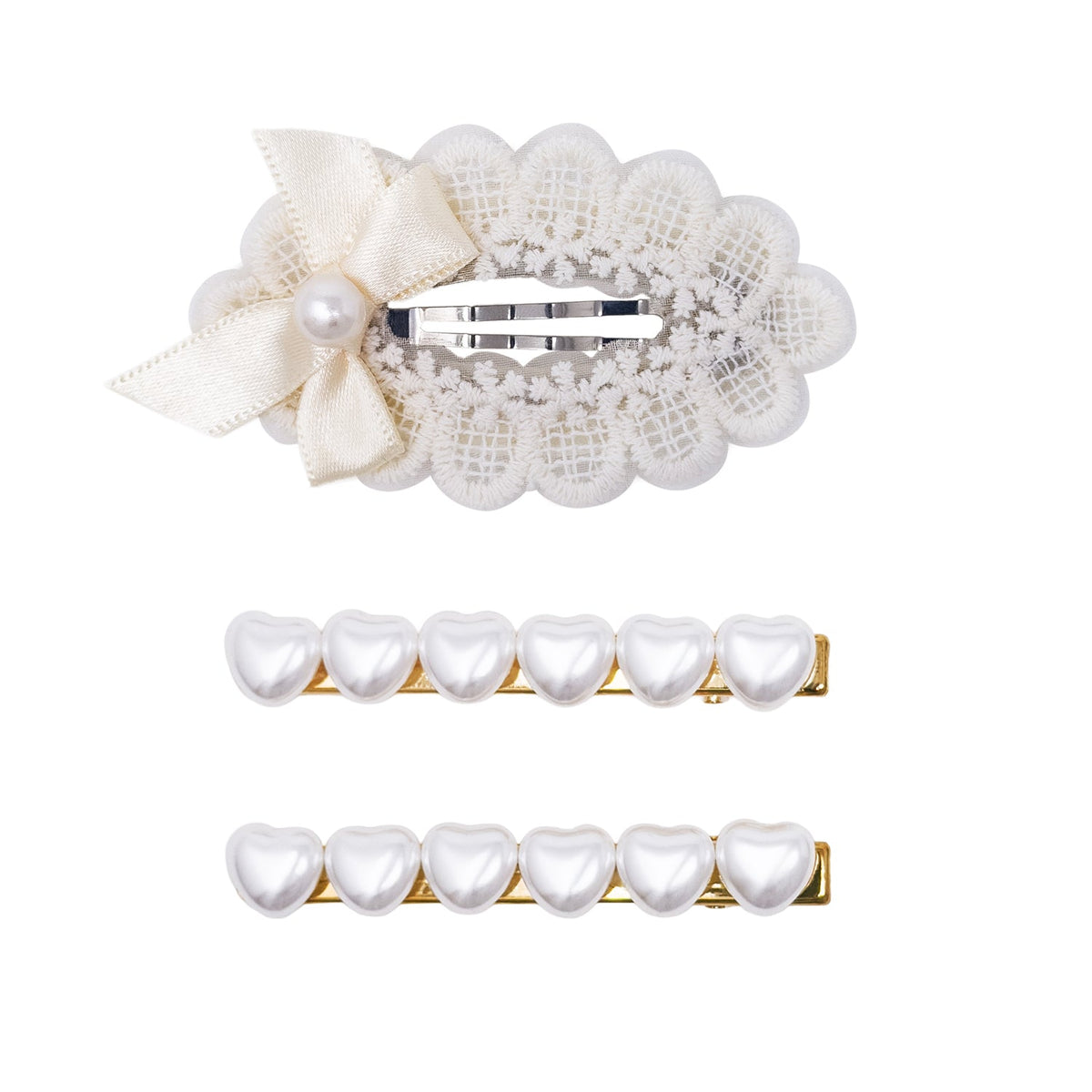 Three pearl hair clips on a white background: one large cream lace and satin bow clip, and two smaller gold clips with white pearl heart shapes.