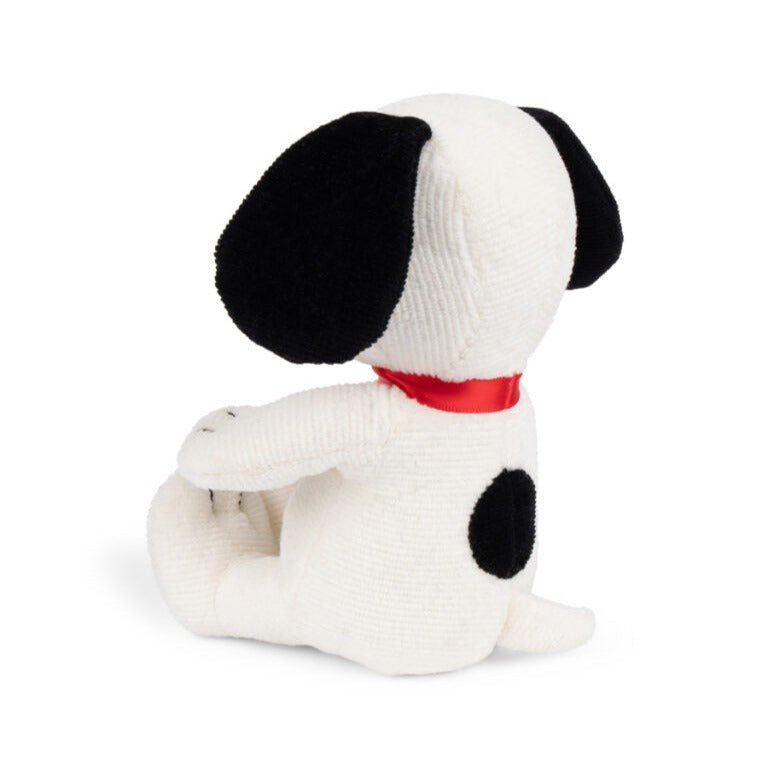 Stuffed Snoopy toy, white corduroy, black ears and spots, red collar, sitting.