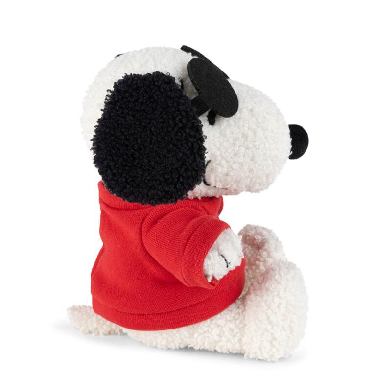 Side view of a Snoopy plush toy wearing a red hoodie.