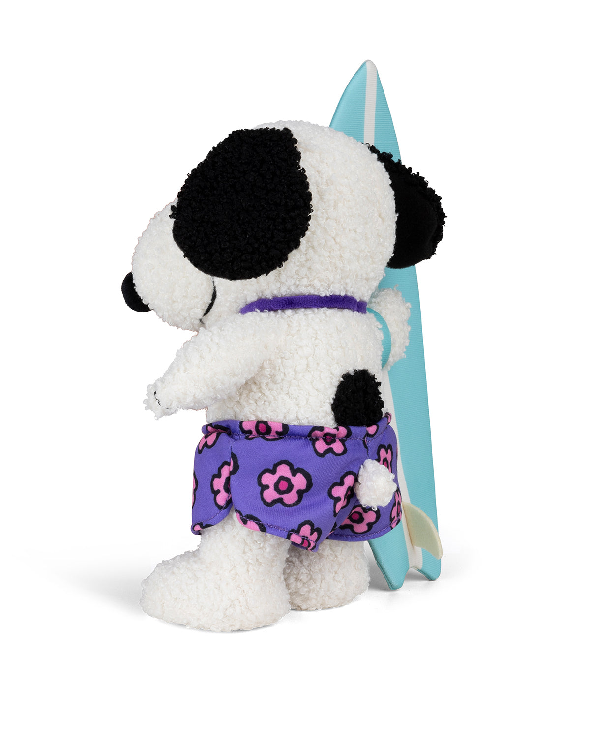 Stuffed dog toy wearing floral swim trunks with a surfboard.