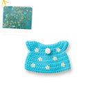 Crocheted blue pet clothing with white flower accents and button.  Van Gogh painting in background.
