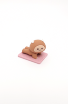 Brown animal-like cartoon character in yoga position on pink mat.