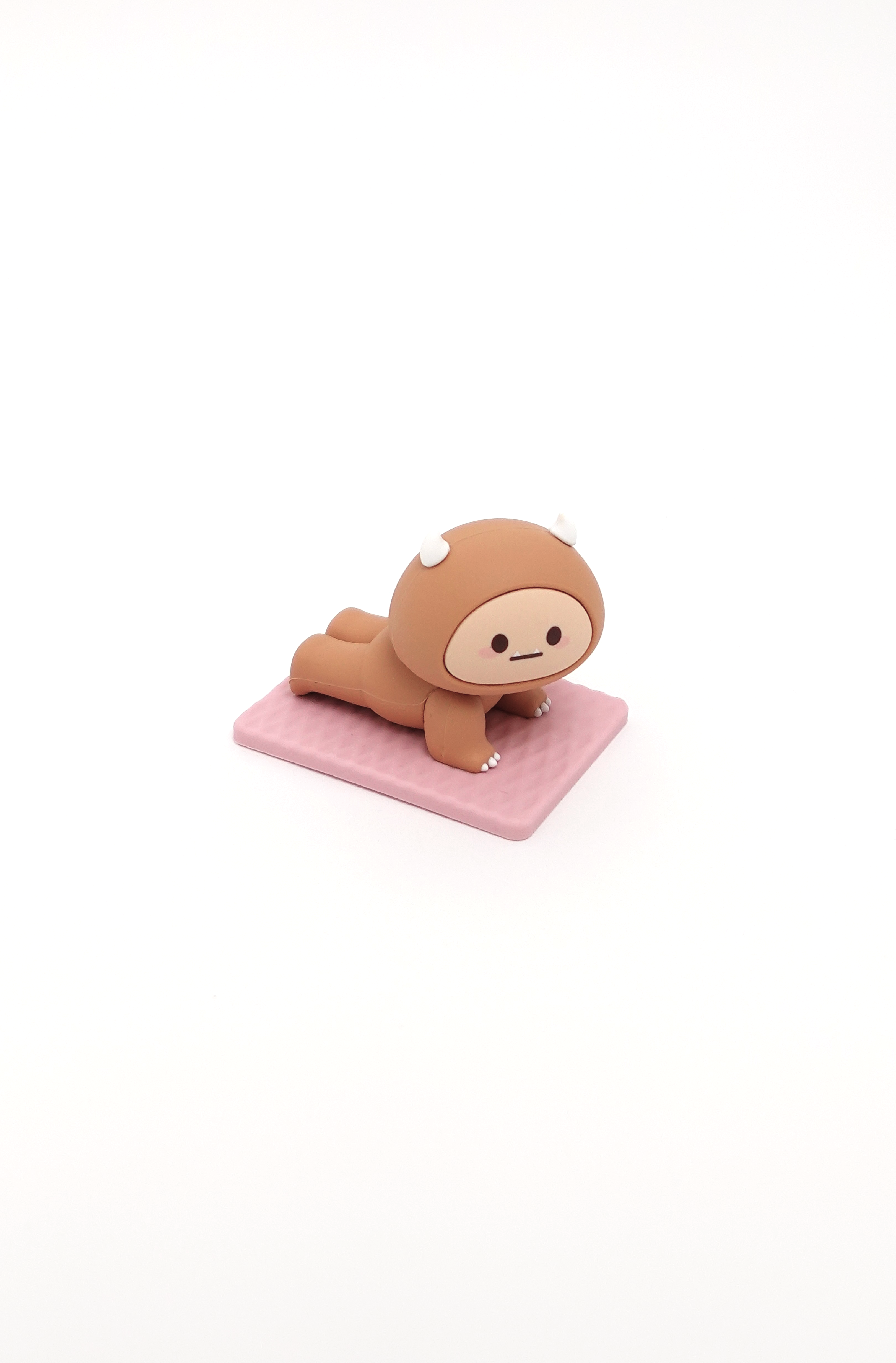 Brown animal-like cartoon character in yoga position on pink mat.