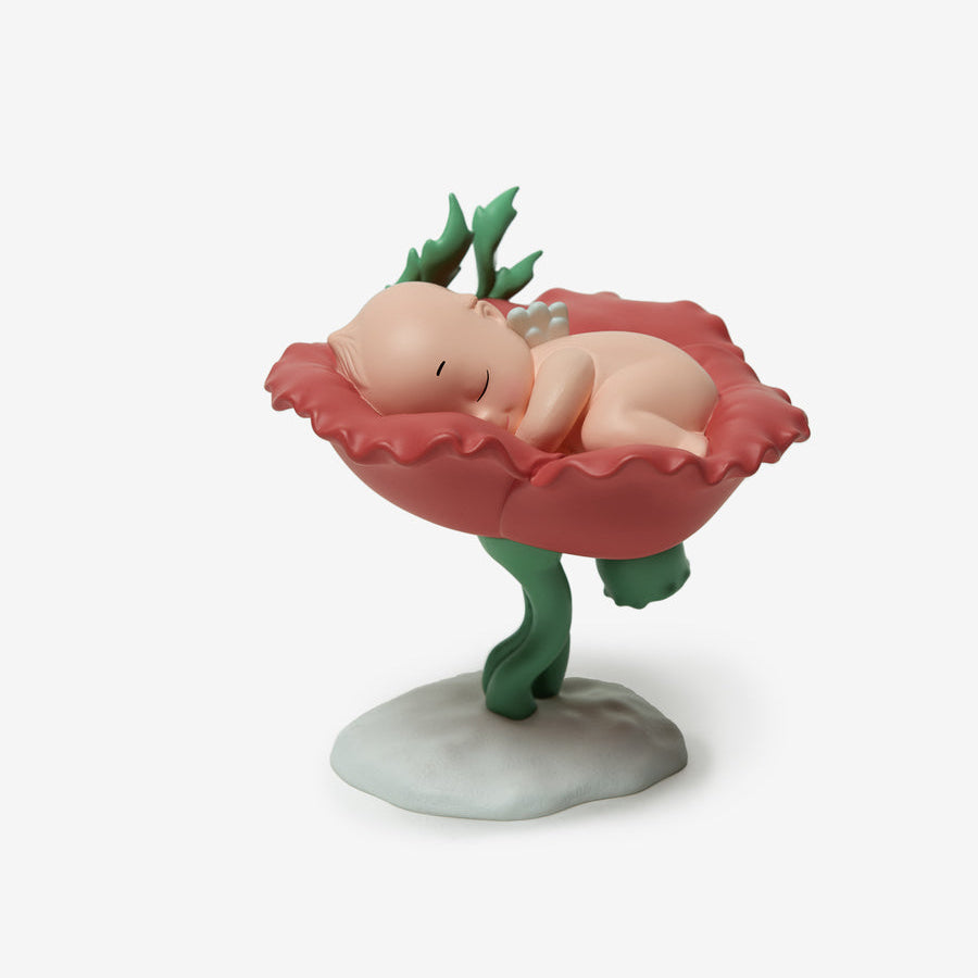 Figurine of a baby in a flower bed on a white background