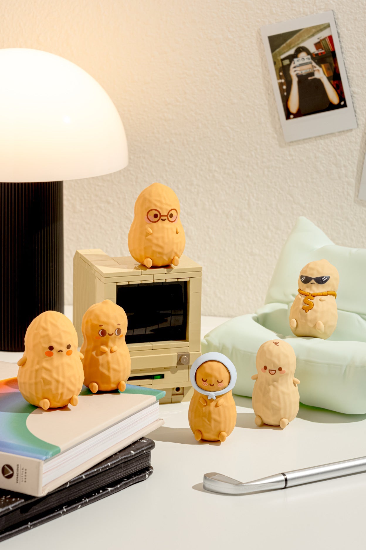Small yellow plush toys with various expressions on a desk with a lamp and books in the background.