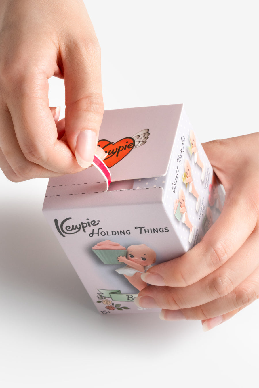 Hands opening a small box with cartoon characters on a white background