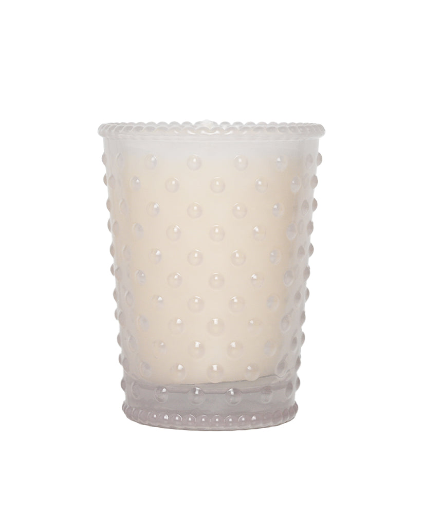 White candle with a textured, bead-like exterior on a white background