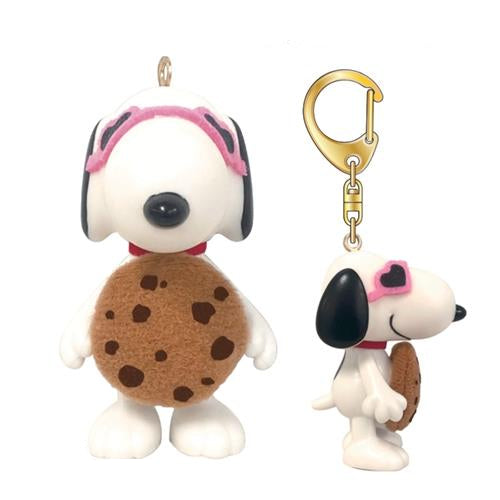 Two Snoopy figures; one Christmas ornament, one keychain. Snoopy with pink goggles and a cookie.