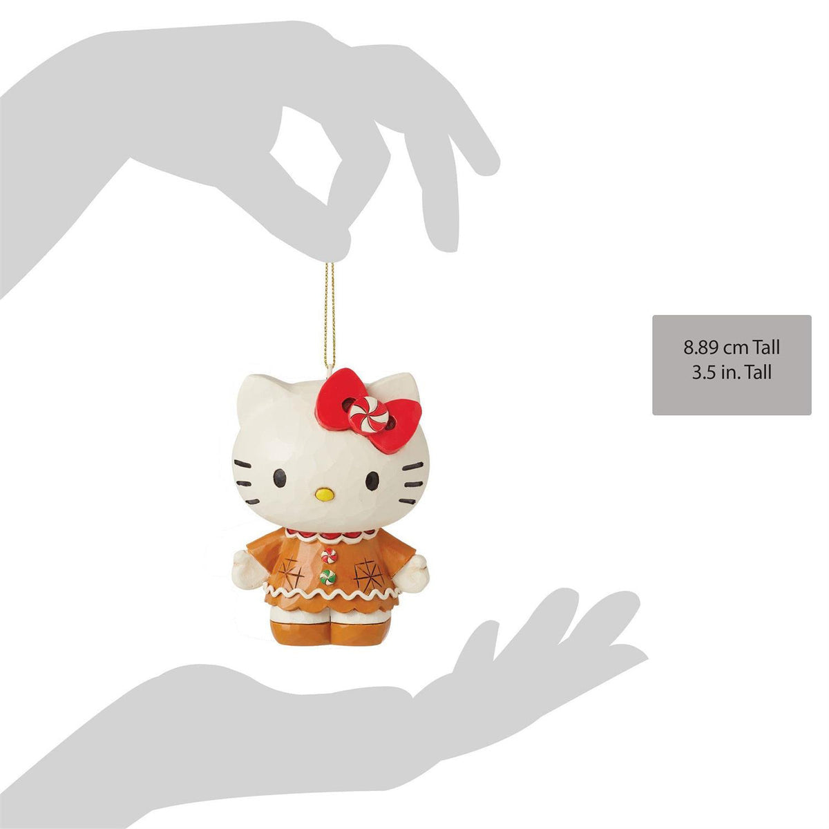 Hello Kitty ornament wearing a gingerbread-style outfit, held by hand.