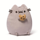 Gray plush Pusheen cat holding a cookie.