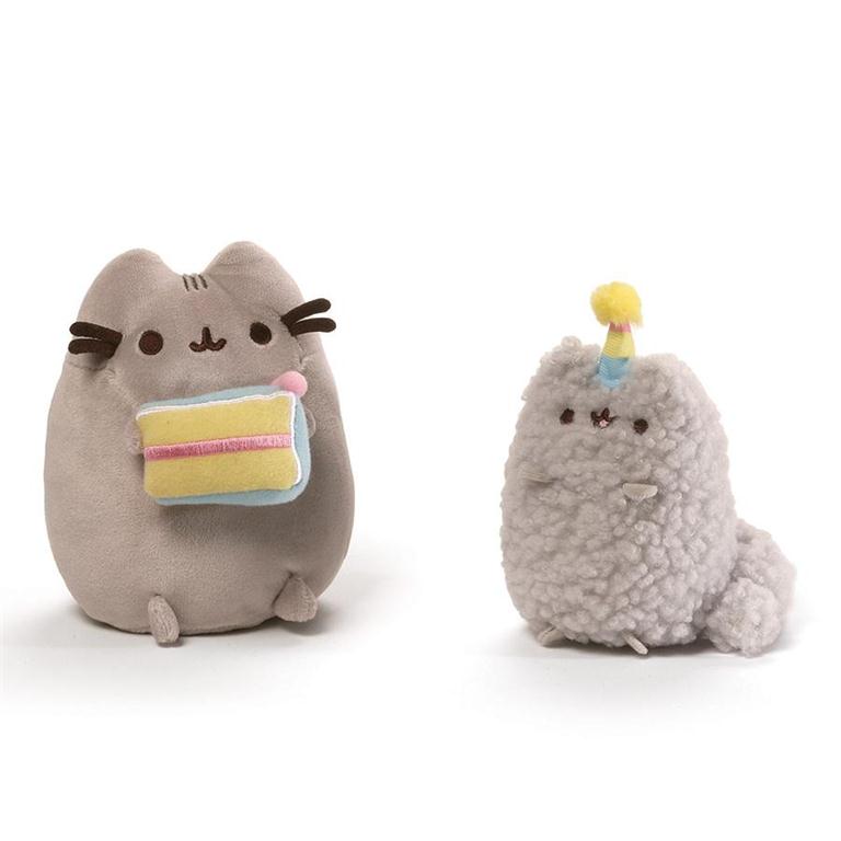 Two plush cat toys, one holding cake and the other a unicorn with a party hat, on a white background.