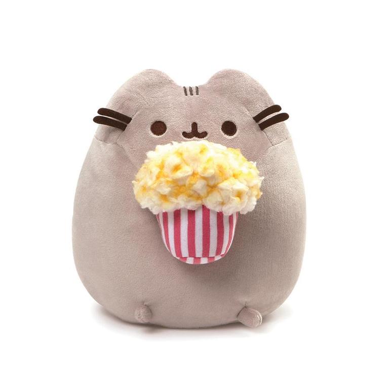 A Pusheen plush toy holds a plush bucket of popcorn.