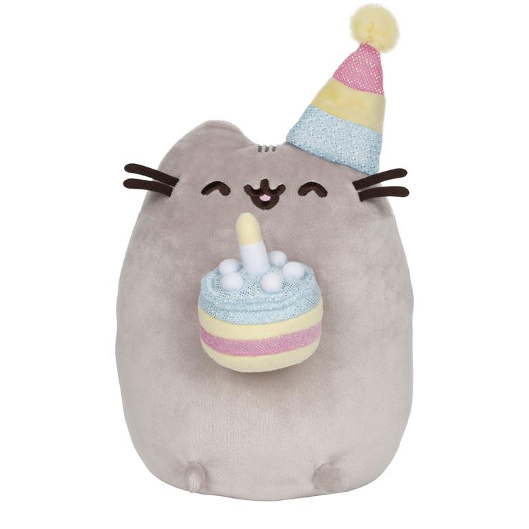 A gray cat plush toy wearing a birthday hat and holding a birthday cake.