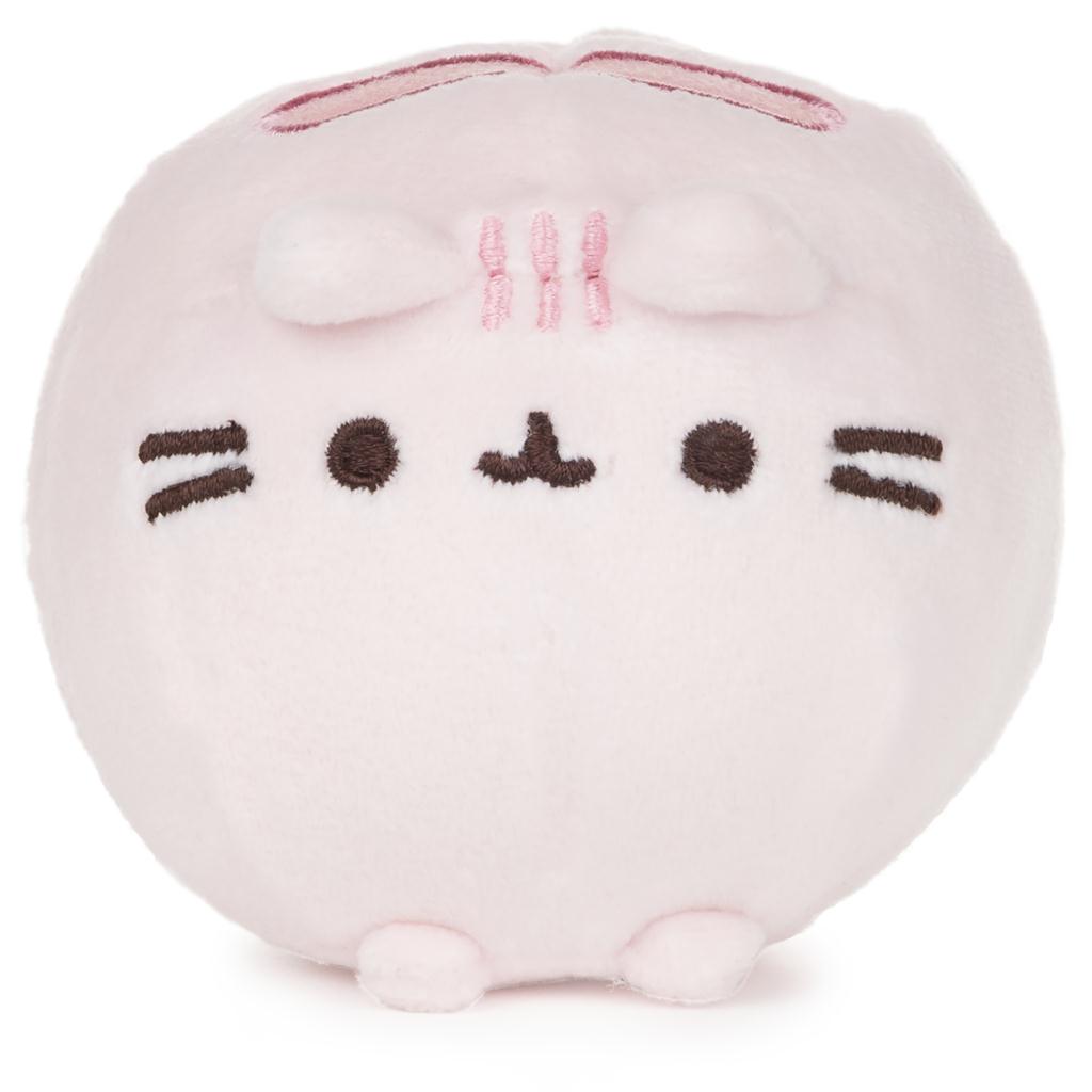 Pink round plush toy with a simple face design on a white background